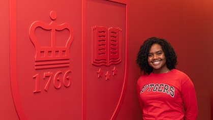 Large Rutgers wall all red with poc woman in Rutgers sweater