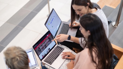3 young female students with their own laptop, engaging together, pointing to screens