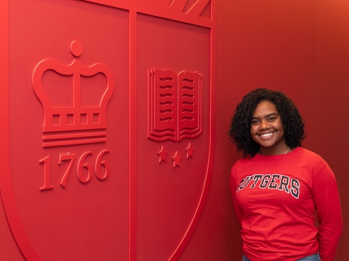 Large Rutgers wall all red with poc woman in Rutgers sweater